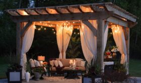 Beautiful backyard Toronto retreat with wooden structure, drapes, couches, lighting, candles, cushions and more.